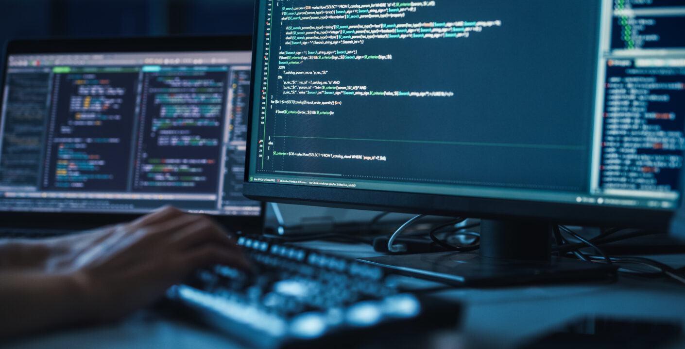 Uma pessoa digitando código na frente de um computador