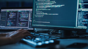 Uma pessoa digitando código na frente de um computador