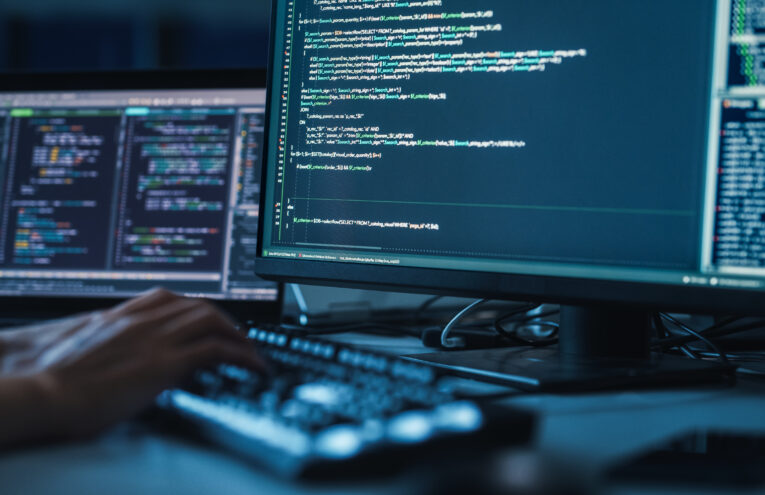 Uma pessoa digitando código na frente de um computador