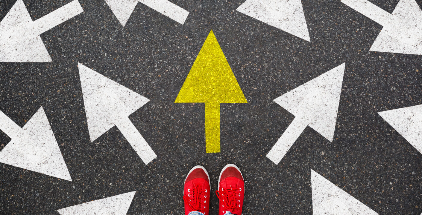 Person standing on the road to future life with many direction sign point in different ways and only yellow one. Decision making is very hard, but you have a choice and right way