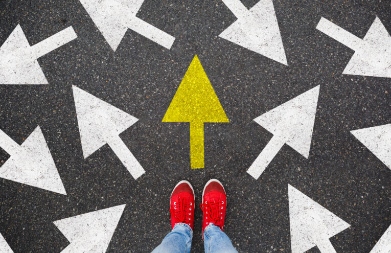 Person standing on the road to future life with many direction sign point in different ways and only yellow one. Decision making is very hard, but you have a choice and right way