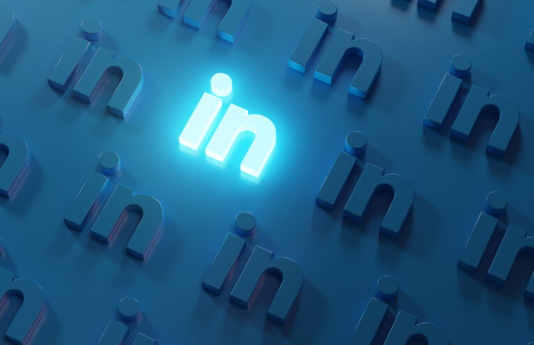 Vários logos do linkedin em alto relevo, estilo 3D, sendo um dos logos em destaque e brilhante, em um fundo azul